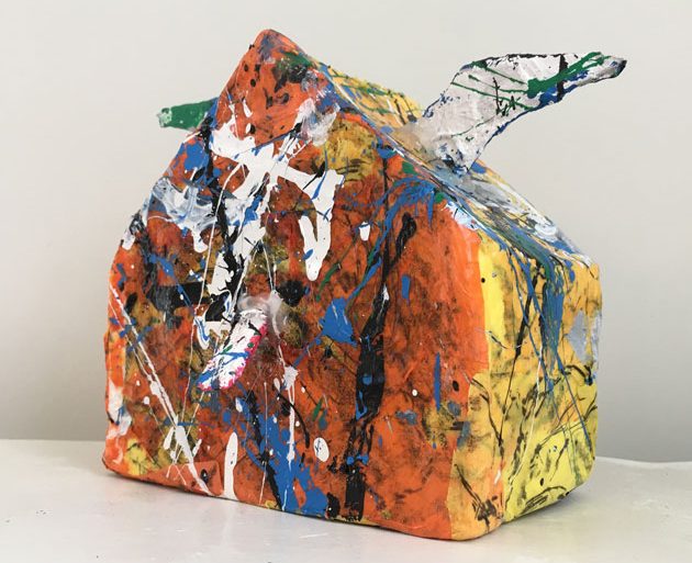 Abstract sculpture of a house with painterly splashes of paint in bright colors.